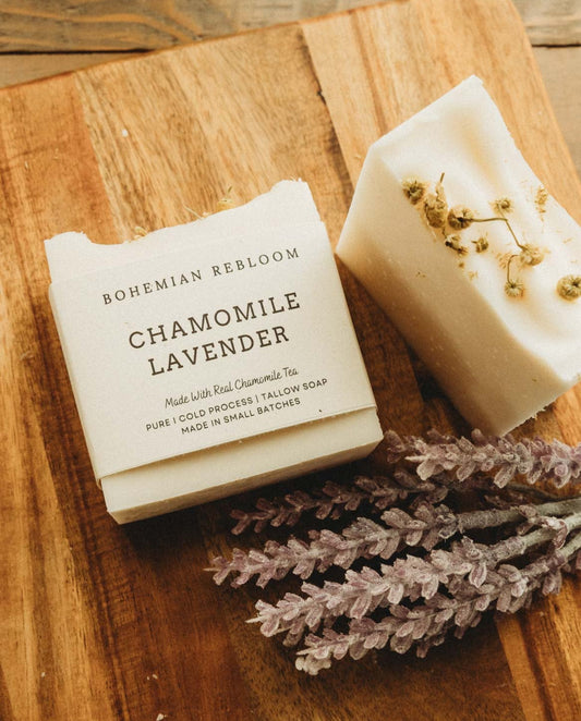 Two bars of chamomile lavender soap with Bohemian Rebloom label on a wooden board with dried lavender flowers.